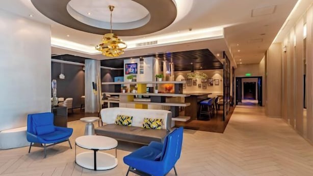 A modern lobby with a central seating area, a reception desk, and a staircase leading to upper floors. - Orange Hotel (Hefei Huaihe Road Pedestrian Street Dadongmen Metro Station) (Hefei)