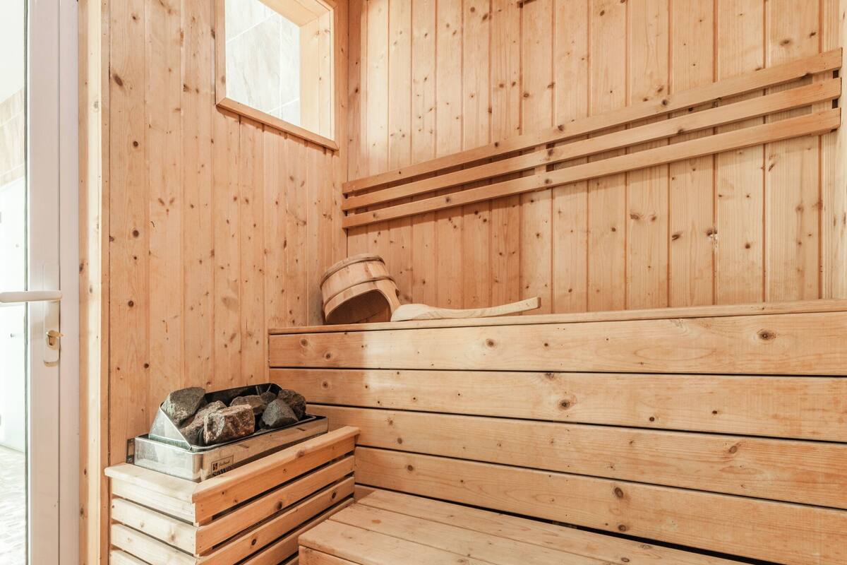 A wooden sauna with benches and a stone heater.