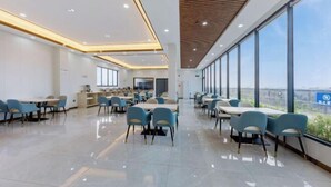 Un comedor amplio y moderno con ventanas grandes, piso pulido y diferentes opciones de asientos.