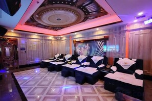 A hotel lobby with a modern design, featuring a central seating area with tables and chairs, a decorative ceiling, and a patterned floor. - Licheng Hotel (Zhongshan Xiaolan High-speed Railway Dongsheng Station Branch) (Zhongshan)