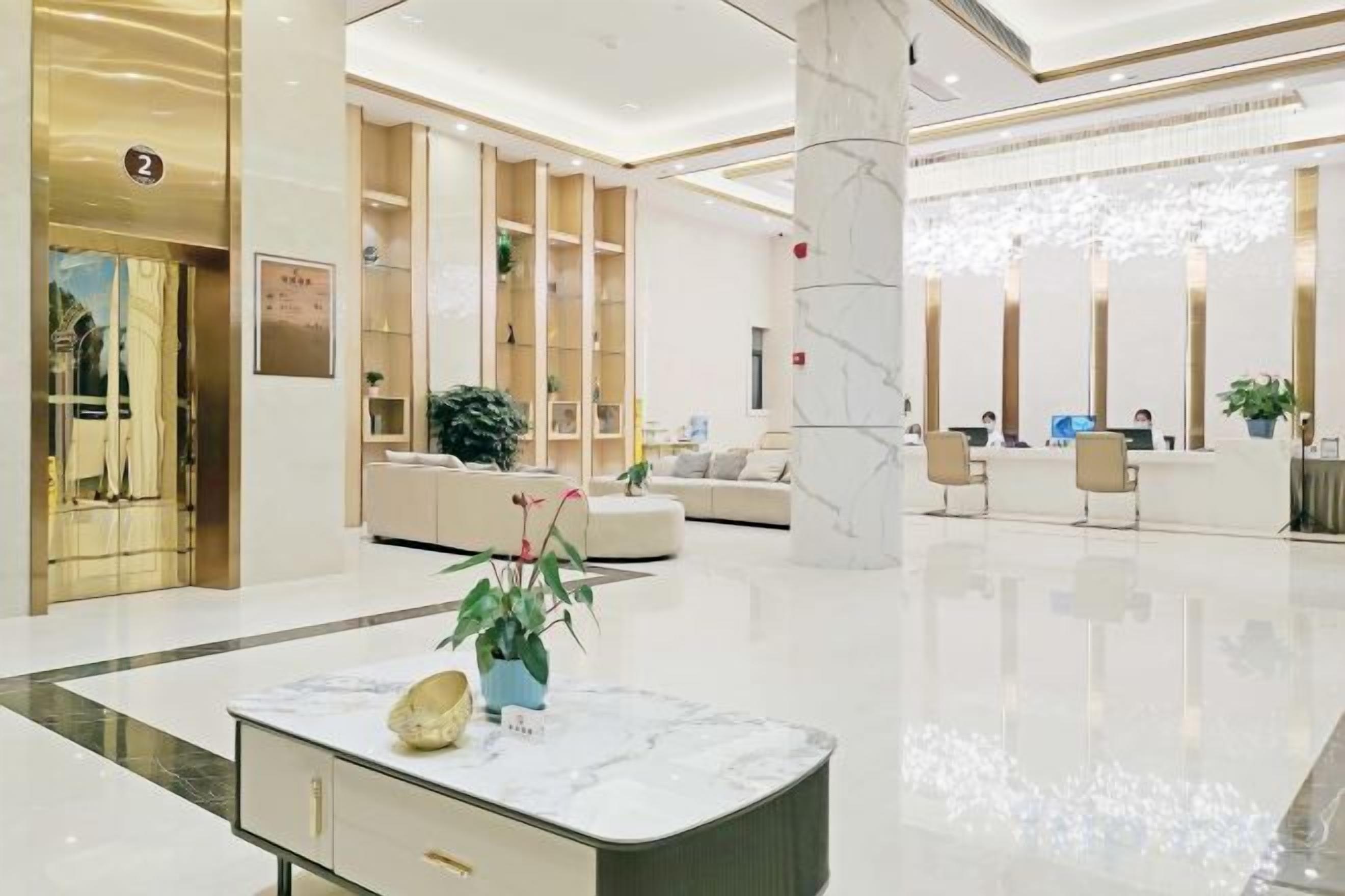 A modern lobby with a reception desk, seating area, and a marble reception counter.