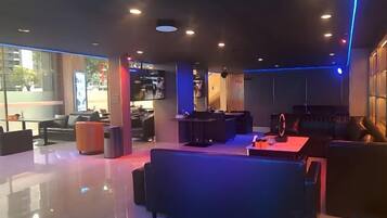 A modern interior with a seating area, a reception desk, and a television.