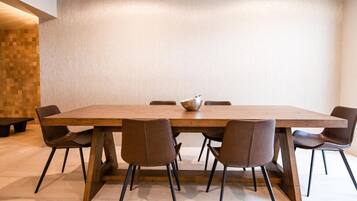 A modern dining area with a long wooden table, six brown chairs, and a central bowl.