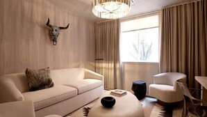Ein modernes Wohnzimmer mit einer Couch, Sesseln, einem Couchtisch und einer Wanddekoration mit einem Stierkopf.