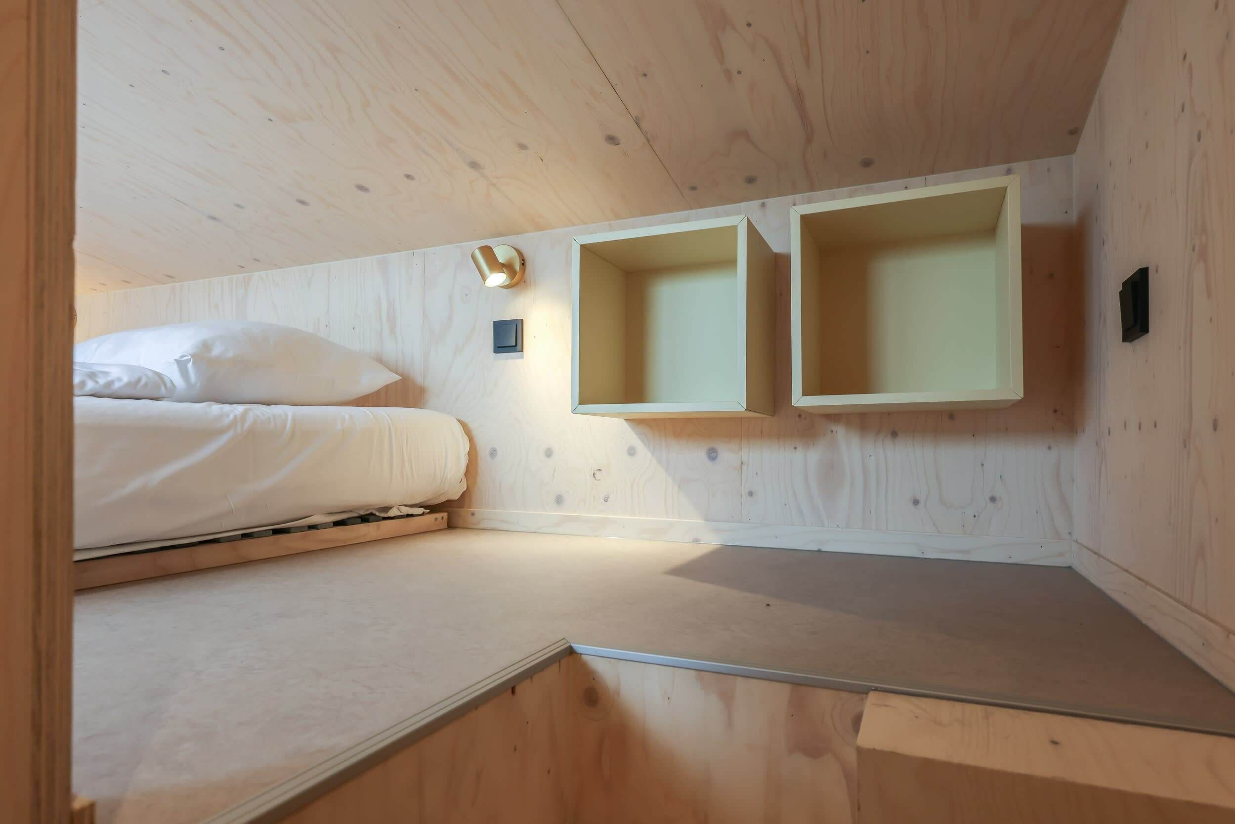 Quarto com beliche, paredes de madeira e prateleiras embutidas.