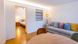 Una sala moderna con un sofá, una mesa de comedor y una lámpara.