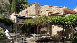 A stone building with a courtyard, including a pergola and a statue. - Fabulous houses with breathtaking views in a peaceful and stunning environment (Suzette)