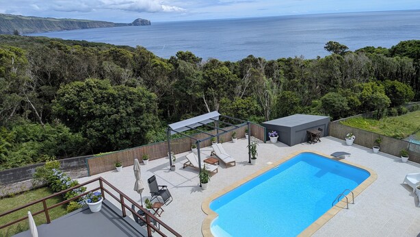 A pool area with lounge chairs, a small deck, and a view of the ocean. - Amazing 180° Ocean View 3 Bedroom Villa w/ Swimming Pool  (Capelo - Horta)