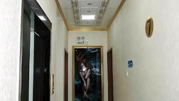 A hallway with a door, a framed picture, and a light switch.