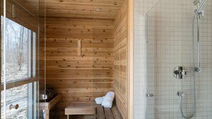 A wooden cabin with a bench, a small table, and a shower area. - Chalet Nova - Spa, Sauna & in the Nature (Chertsey)