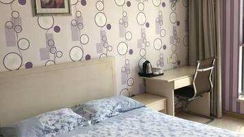 Een slaapkamer met een bed, een bureau en een stoel.