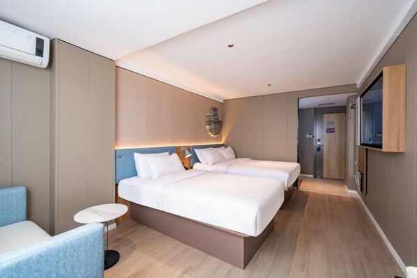 A hotel room with a large bed, a small round table, and a blue armchair. - Home Inn Neo (Quanzhou Bell Tower West Street) (Quanzhou)
