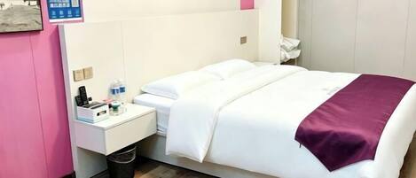 A hotel room with a bed, a nightstand, a trash bin, and a wall-mounted shelf.