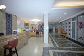 A hotel lobby with a reception desk, a seating area, and a decorative horse statue.