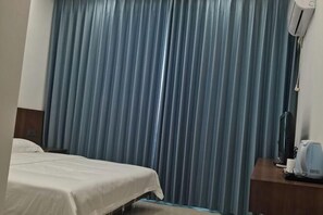 A hotel room with a bed, a desk with a coffee maker, and a wall-mounted air conditioner. - Hengyang Nanyue Hengshan Qingshan Yunju (Hengyang)