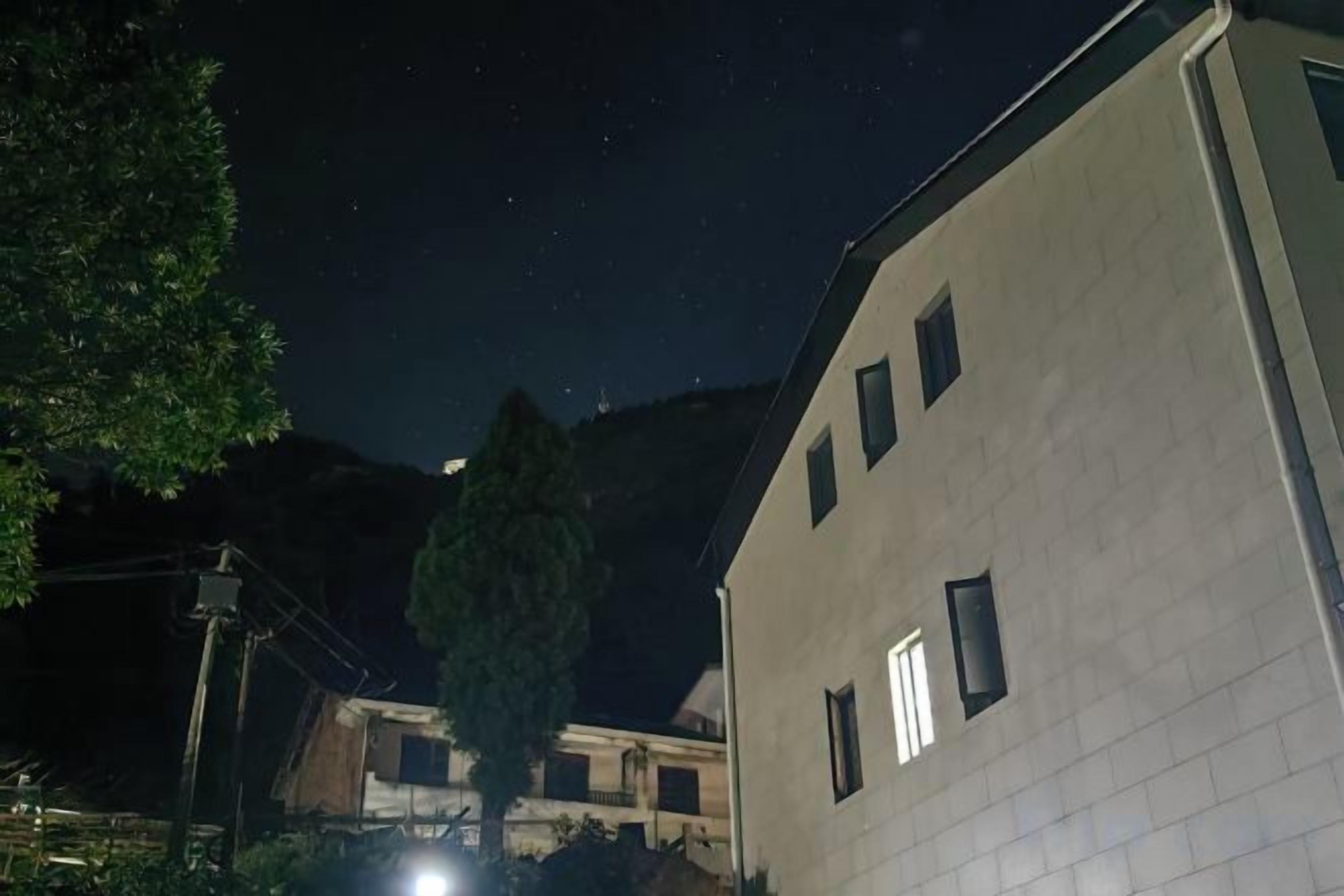 Un edificio con múltiples ventanas y un cielo nocturno lleno de estrellas.