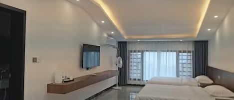 A modern hotel room with a large bed, a TV, a bedside table, and a window with curtains.