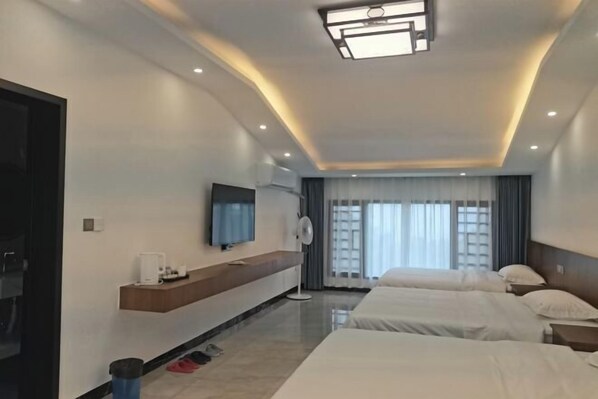 A modern hotel room with a large bed, a TV, a bedside table, and a window with curtains. - Hengyang Nanyue Hengshan Qingshan Yunju (Hengyang)