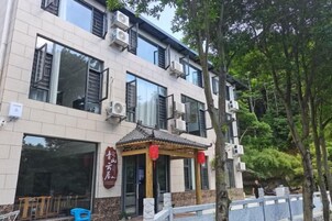 Un edificio con varias ventanas, un acceso cubierto y un letrero con caracteres chinos.