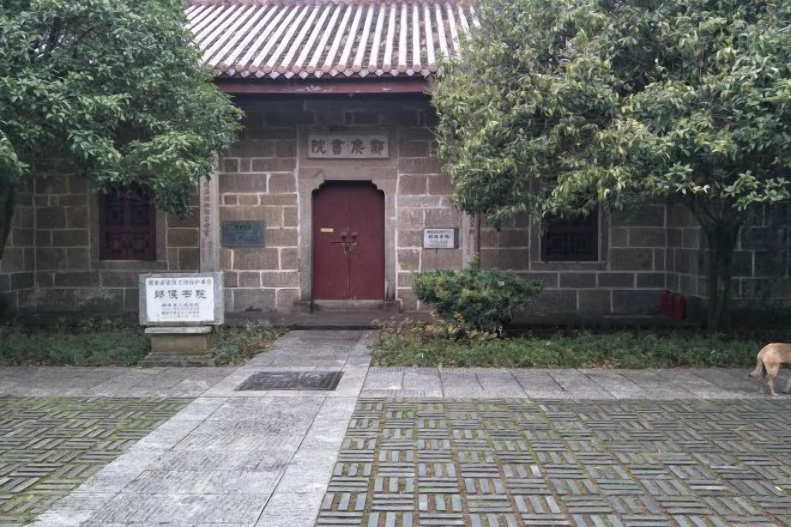 A traditional building with a red door, stone walls, and a tiled roof.