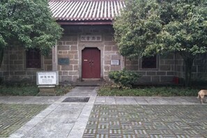 A traditional building with a red door, stone walls, and a tiled roof.
