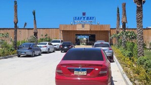 Ein Parkplatz vor einem Gebäude, auf dessen Schild „SAFEY BAY NEW ALAMEIN CITY“ steht.
