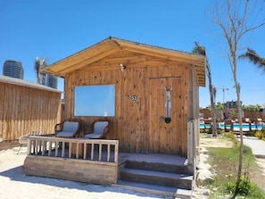 A wooden cabin with a balcony, numbered 53, featuring a mounted animal head and a large window.