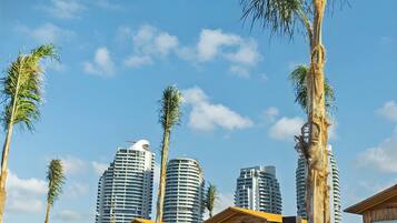 Privat strand, hvit sand, solsenger og parasoller