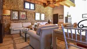 A cozy living room with stone walls, a wooden ceiling, and a mix of sofas and chairs. - Nice home in Partinico with WiFi (Partinico)