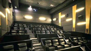 Ein modernes Kino mit terrassenförmigen Sitzen und dunklem Innenraum.