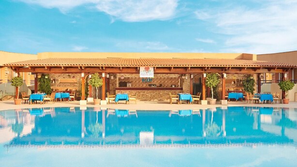 Ein Hotel mit Pool, Außenbereich und Bar.