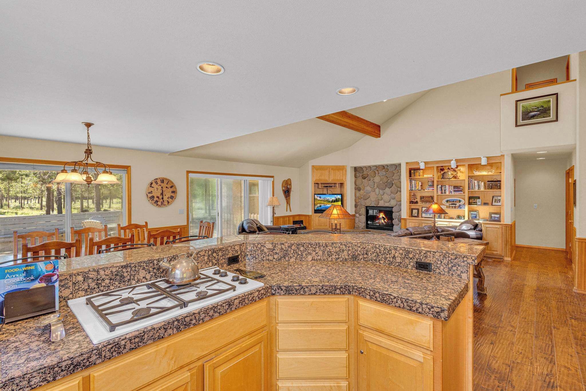 A spacious kitchen with granite countertops, wooden cabinets, and a built-in stove.