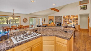 A spacious kitchen with granite countertops, wooden cabinets, and a built-in stove.