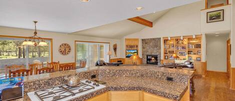 A spacious kitchen with granite countertops, wooden cabinets, and a built-in stove.