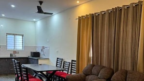 Una sala de estar moderna con un sofá, una mesa de centro de vidrio y un comedor con sillas y una mesa.