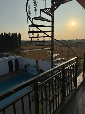 A spiral staircase with a pool in the foreground. - H&R Paradise Villa (Devanahalli)