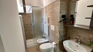 Un baño moderno con ducha, bidé y lavamanos.
