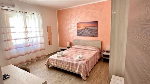 Un dormitorio con una cama, un escritorio y un cuadro en la pared.