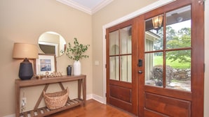 A wooden console table with a lamp, a mirror, and decorative items.