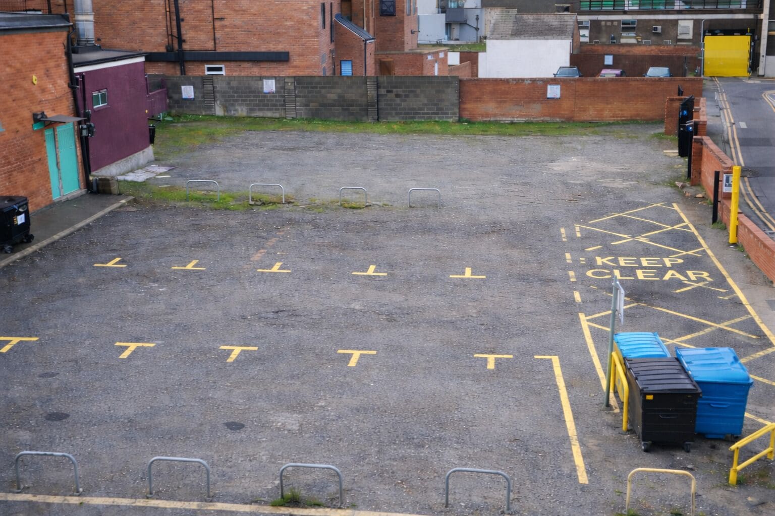 Un área de estacionamiento con líneas amarillas y la señalización 'KEEP CLEAR'.