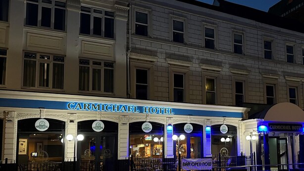 The exterior of the Carmichael Hotel with a blue awning and multiple entrance doors. - The Carmichael - Hull City Centre (Hull)