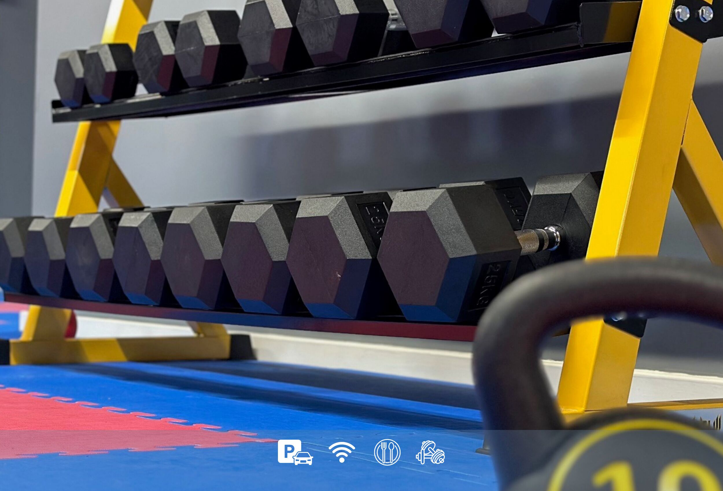 Un banc de musculation avec des disques d’haltères hexagonaux et un cadre jaune.