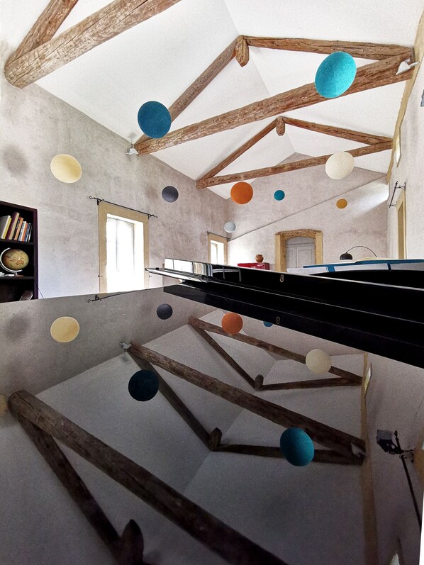 A room with exposed wooden beams, a long table, and hanging spherical objects. - La Bastide du Farfadet (Laudun)