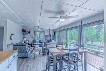Escape to our charming cabin nestled in nature, featuring a spacious open-concept living, dining, and kitchen area.