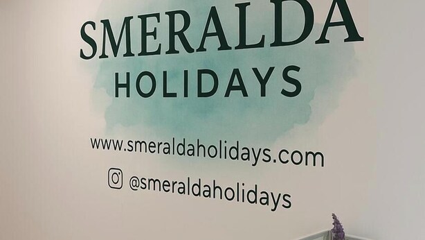 Eine Wand mit dem Text 'SMERALDA HOLIDAYS' und einer Webadresse.