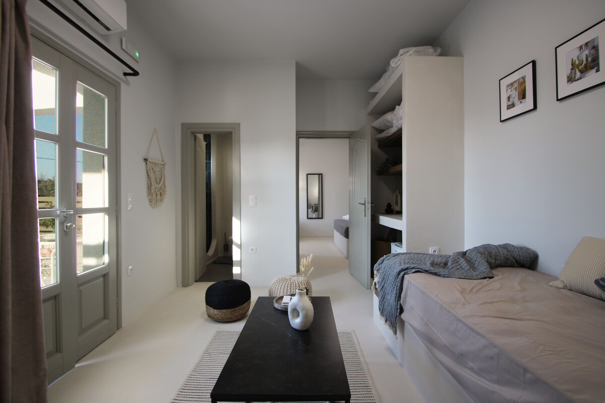 A bedroom with a bed, a bedside table, a wardrobe, and a door leading to a balcony.