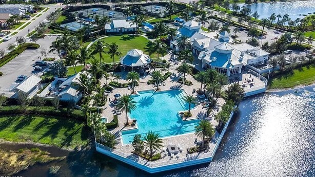 Ein Luftbild eines Resorts mit einem zentralen Schwimmbecken, mehreren Villen und einem Wasserkörper.