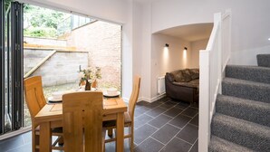 A modern interior with a dining area, a sofa, and a staircase. - 2 bedroom home within walking distance of the town - Pass the Keys (Shrewsbury)