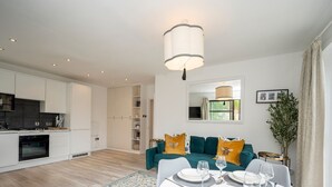 A modern apartment with a dining area, kitchen, and living room. - London apartment - Waterfront Terrace & Parking - Pass the Keys (London)