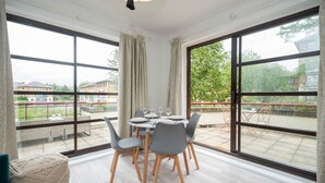 A dining area with a table set for four, large windows, and a view of the outside. - London apartment - Waterfront Terrace & Parking - Pass the Keys (London)